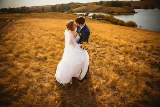 young bride and groom on the background of the field