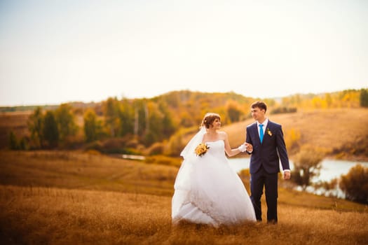 young bride and groom on the background of the field