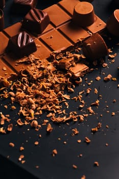 Many candy and chocolate chips on a black background