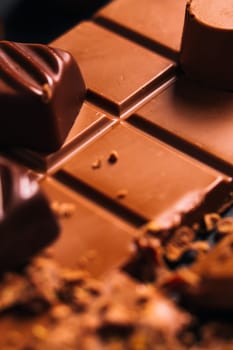 Many candy and chocolate chips on a black background