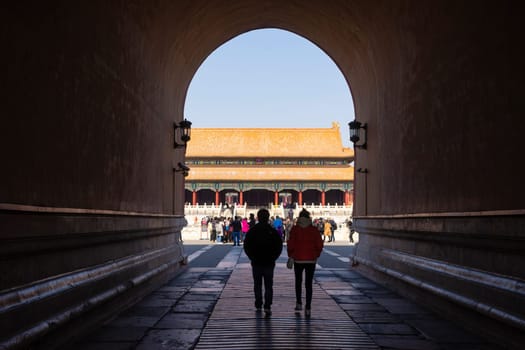 Beijing, China - Mar 16, 2018: View of people walking through the tunnel at the main gate of Forbidden City in Beijing. It is a palace complex in Beijing and a popular tourist attraction.