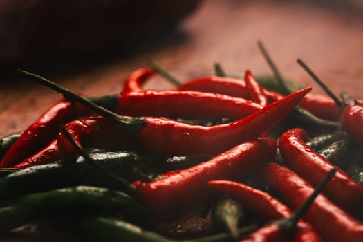 red and green chili peppers close up on wooden background