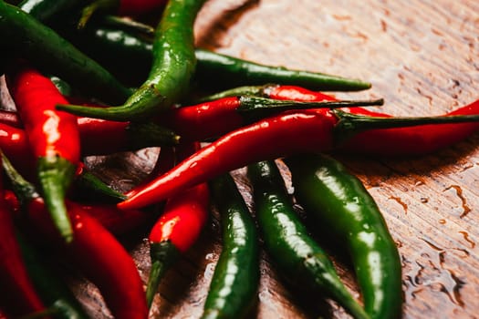 red and green chili peppers close up on wooden background