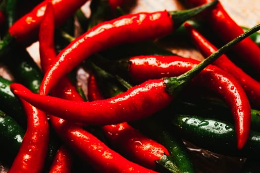red and green chili peppers close up on wooden background