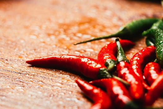 red and green chili peppers close up on wooden background