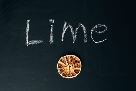 one sliced orange circle on a black background board