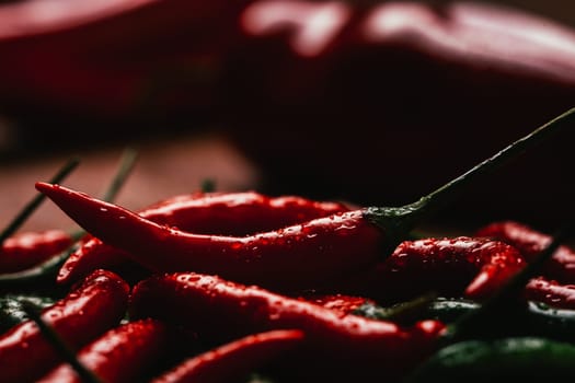 red and green chili peppers close up on wooden background