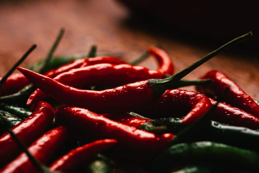red and green chili peppers close up on wooden background