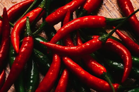 red and green chili peppers close up on wooden background