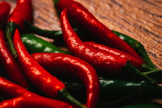 red and green chili peppers close up on wooden background