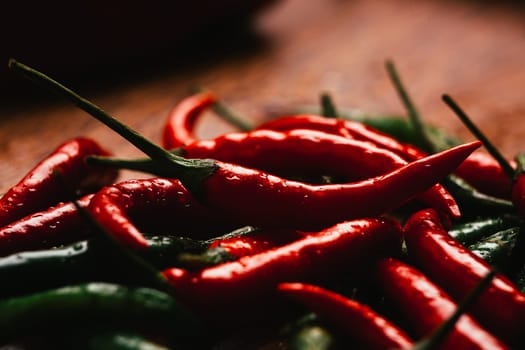 red and green chili peppers close up on wooden background