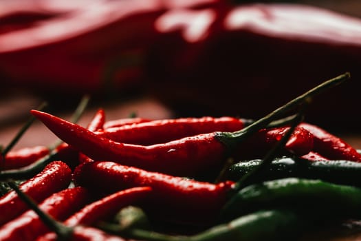 red and green chili peppers close up on wooden background