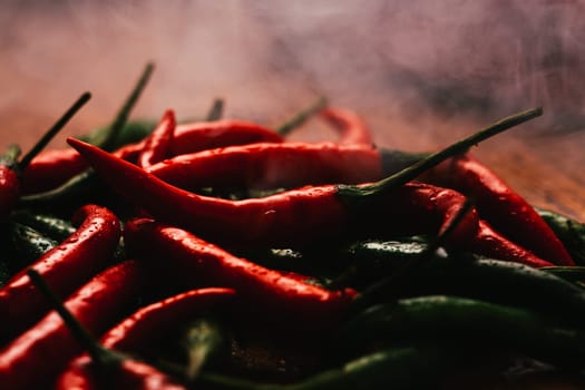 red and green chili peppers close up on wooden background