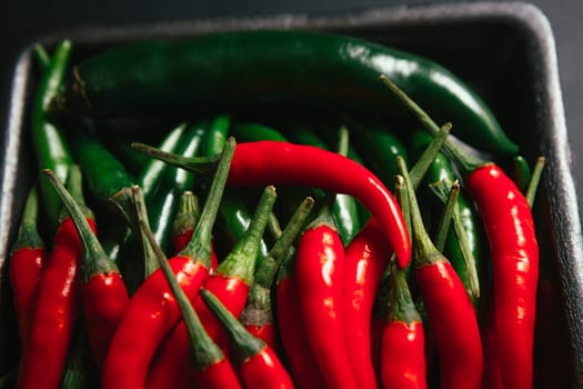 red and green chili peppers close up on wooden background