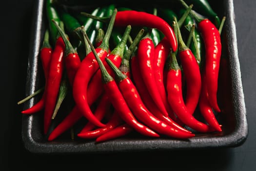 red and green chili peppers close up on wooden background