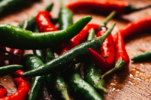 red and green chili peppers close up on wooden background