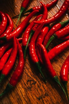 red and green chili peppers close up on wooden background