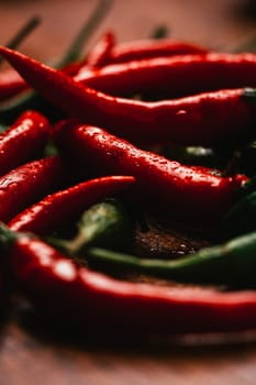 red and green chili peppers close up on wooden background