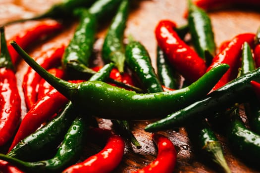 red and green chili peppers close up on wooden background