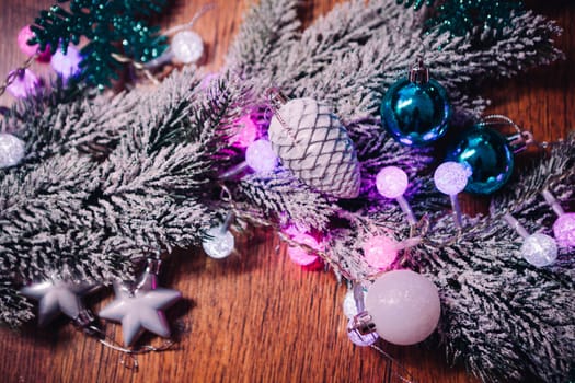 Spruce branches in the snow violet blue and white christmas balls on dark wooden background