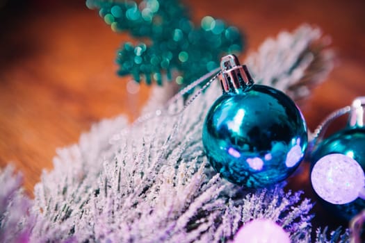 Spruce branches in the snow violet blue and white christmas balls on dark wooden background
