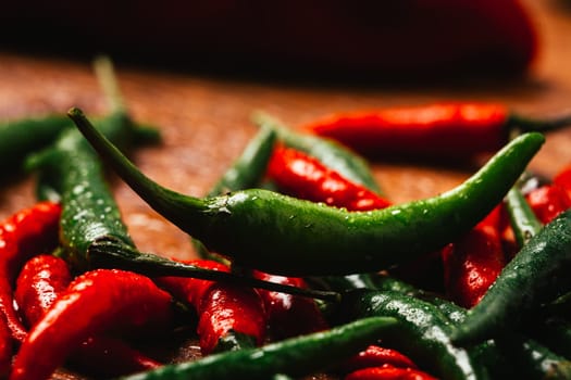 red and green chili peppers close up on wooden background