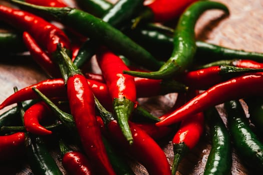 red and green chili peppers close up on wooden background