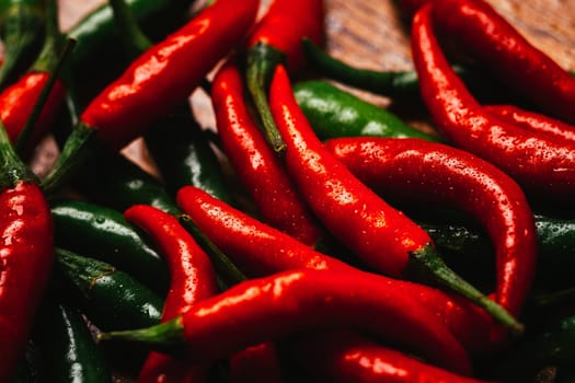 red and green chili peppers close up on wooden background