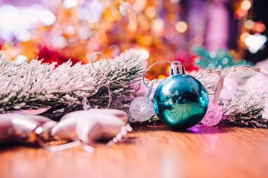 Spruce branches in the snow, and blue balls wooden background