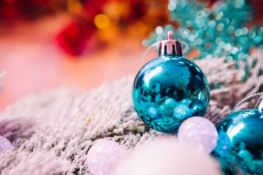 Spruce branches in the snow, and blue balls wooden background