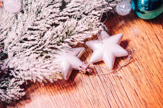 Spruce branches in the snow, and white balls wooden background
