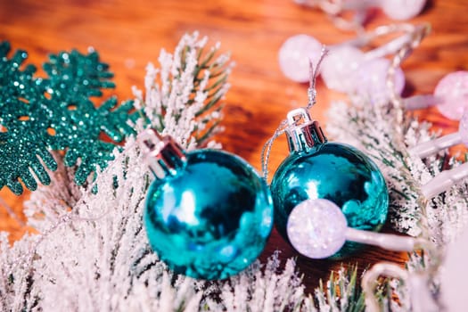 Spruce branches in the snow, and blue balls wooden background