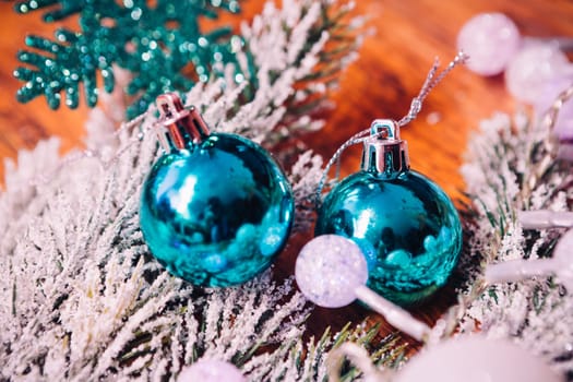 Spruce branches in the snow, and blue balls wooden background