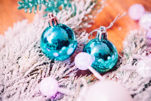 Spruce branches in the snow, and blue balls wooden background