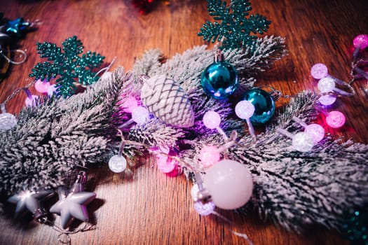 Spruce branches in the snow violet blue and white christmas balls on dark wooden background