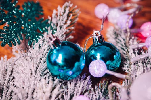 Spruce branches in the snow, and blue balls wooden background