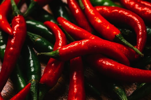 red and green chili peppers close up on wooden background