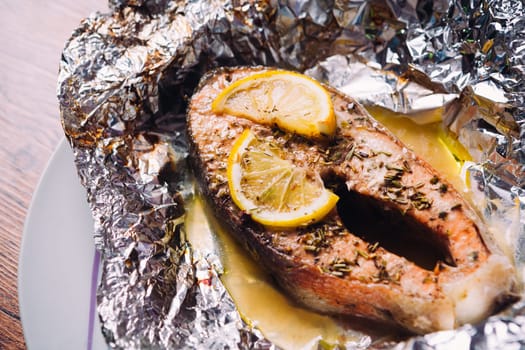 fish steak baked with lemon and herbs in foil