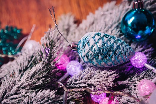 Spruce branches in the snow violet blue and white christmas balls on dark wooden background