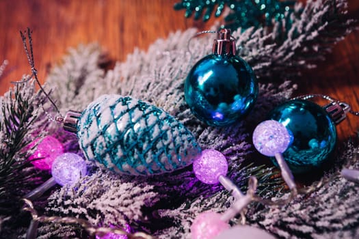 Spruce branches in the snow violet blue and white christmas balls on dark wooden background