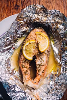 fish steak baked with lemon and herbs in foil