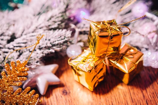Spruce branches in the snow gold and white christmas decoration on wooden background
