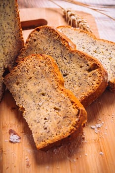 Close slice of fresh bread with poppy seeds on a wooden background