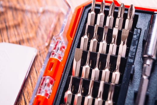 set of nozzles for screwdriver in red box on wooden background