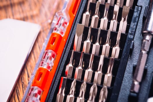 set of nozzles for screwdriver in red box on wooden background