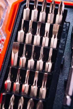 set of nozzles for screwdriver in red box on wooden background