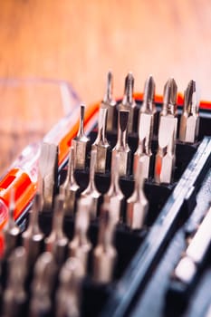 set of nozzles for screwdriver in red box on wooden background