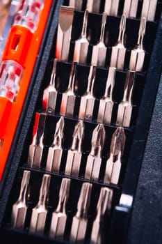 set of nozzles for screwdriver in red box on wooden background