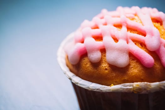 cupcake with pink frosting on a wooden background