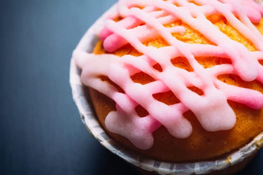 cupcake with pink frosting on a wooden background